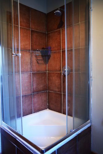 The shower has a sit-in base nearly the depth of a standard bath.